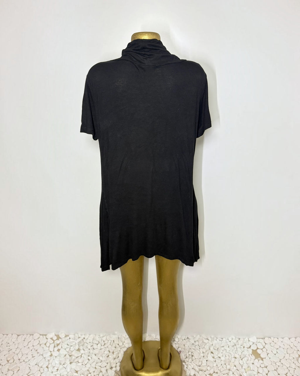 Orvaniwear black short-sleeve tunic with a draped cowl neckline and asymmetric handkerchief hem on a mannequin.