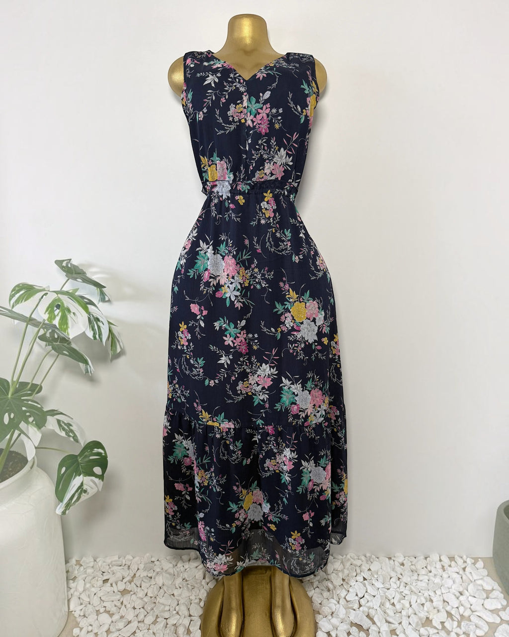 Orvaniwear navy midi dress with pink, yellow, and green floral print, sleeveless V-neck, and tiered ruffle hem.