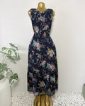 Orvaniwear navy midi dress with pink, yellow, and green floral print, sleeveless V-neck, and tiered ruffle hem.