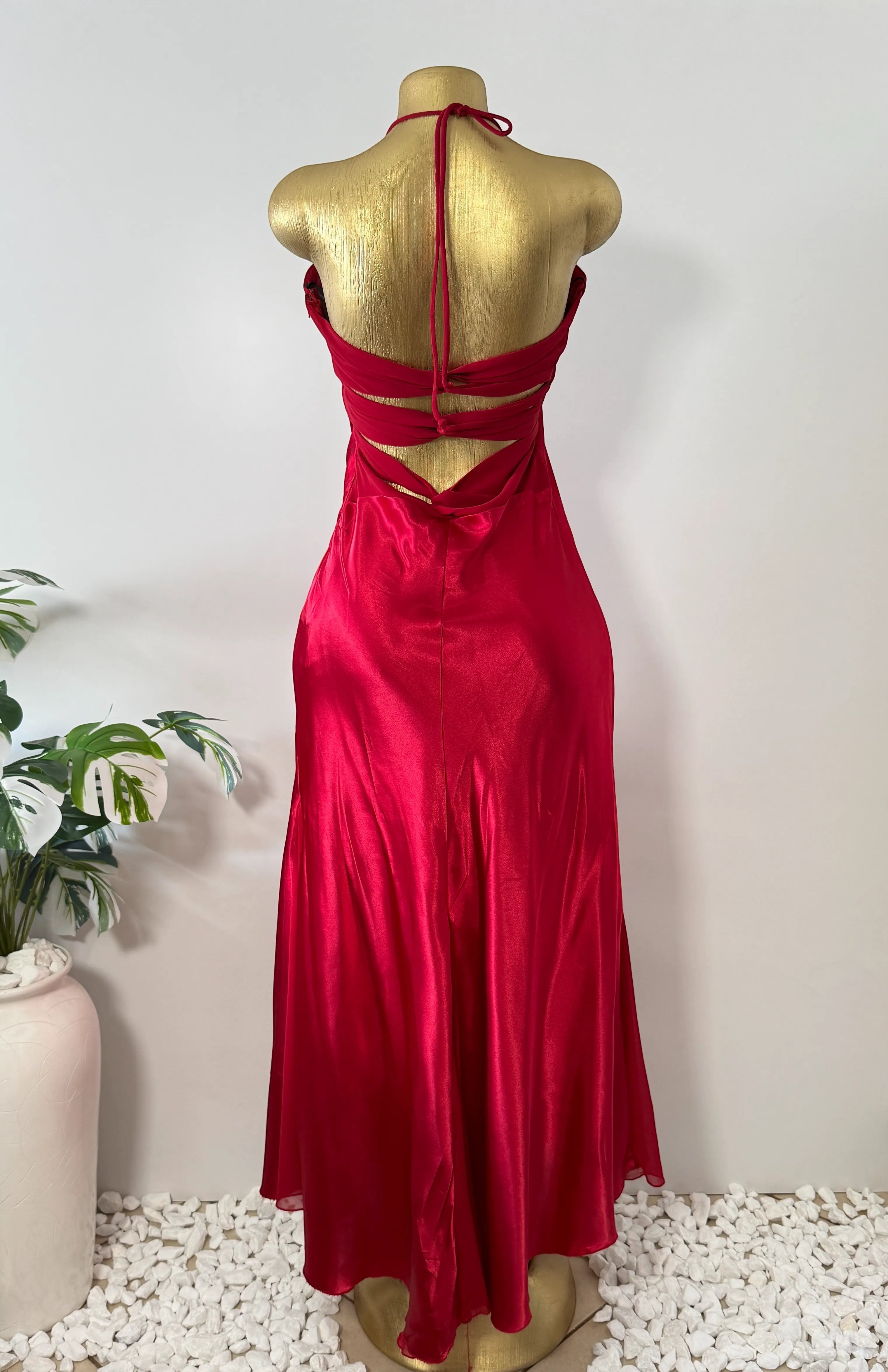 Orvaniwear red satin halter gown with strappy open back detail on a mannequin